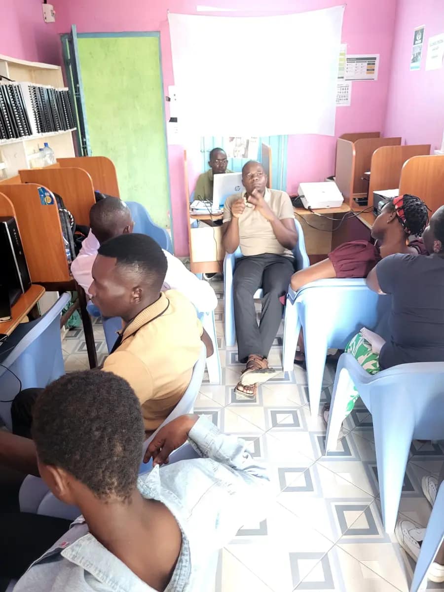 A facilitator talks with young participants seated in the Ogongo Resource Hub computer room during the Digital Marketing Training